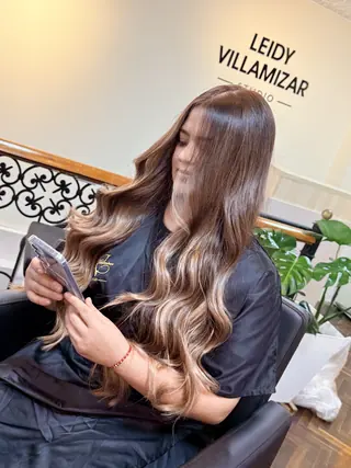 Cabello largo ondulado con reflejos claros en el estudio