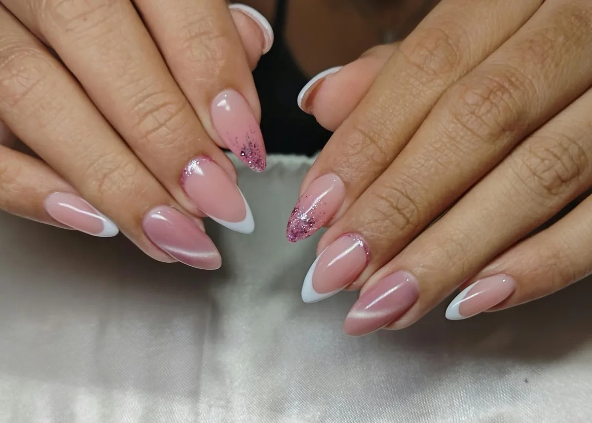 Diseño de uñas rosadas con puntas blancas y detalles decorativos