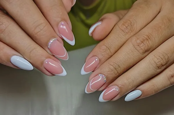 Diseño de uñas rosadas y blancas con trazos decorativos