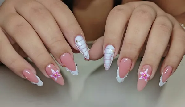 Diseño de uñas rosadas con flores y detalles blancos